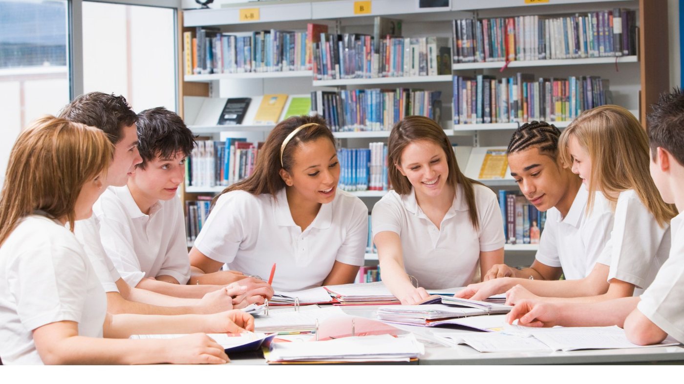 Secondary students working together at a library table